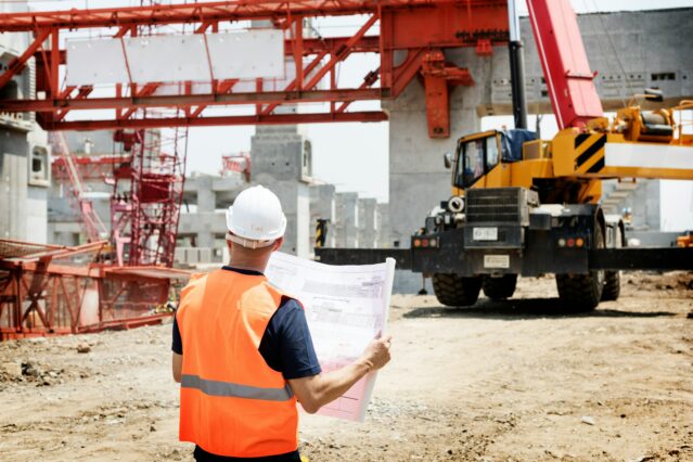 Man holding plans while on construction site